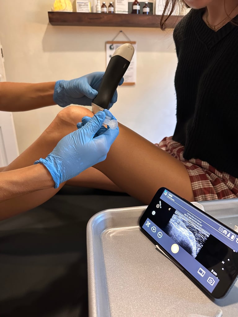 Medical professional applying compression sleeve to patient's leg while taking photo on smartphone
