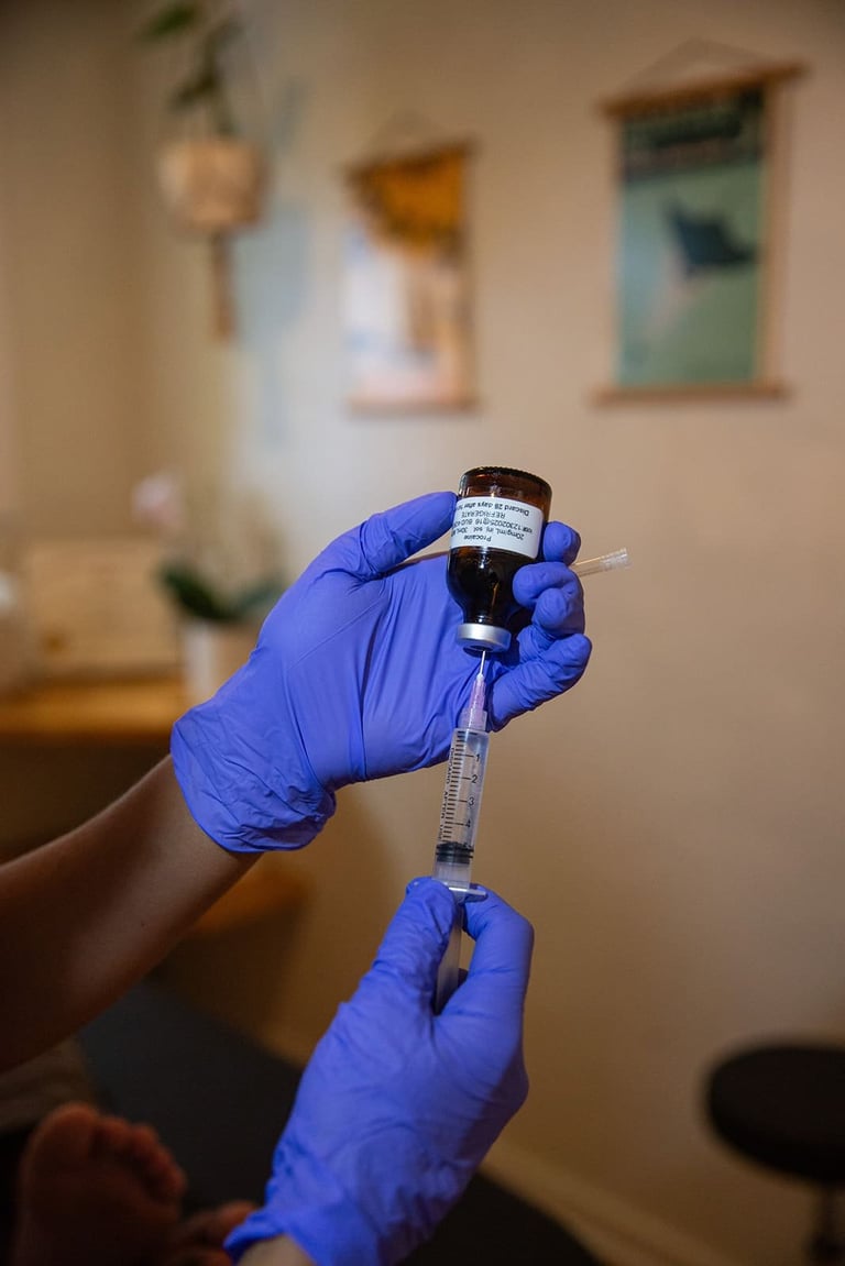 Healthcare worker in blue gloves drawing vaccine from vial with syringe indoors