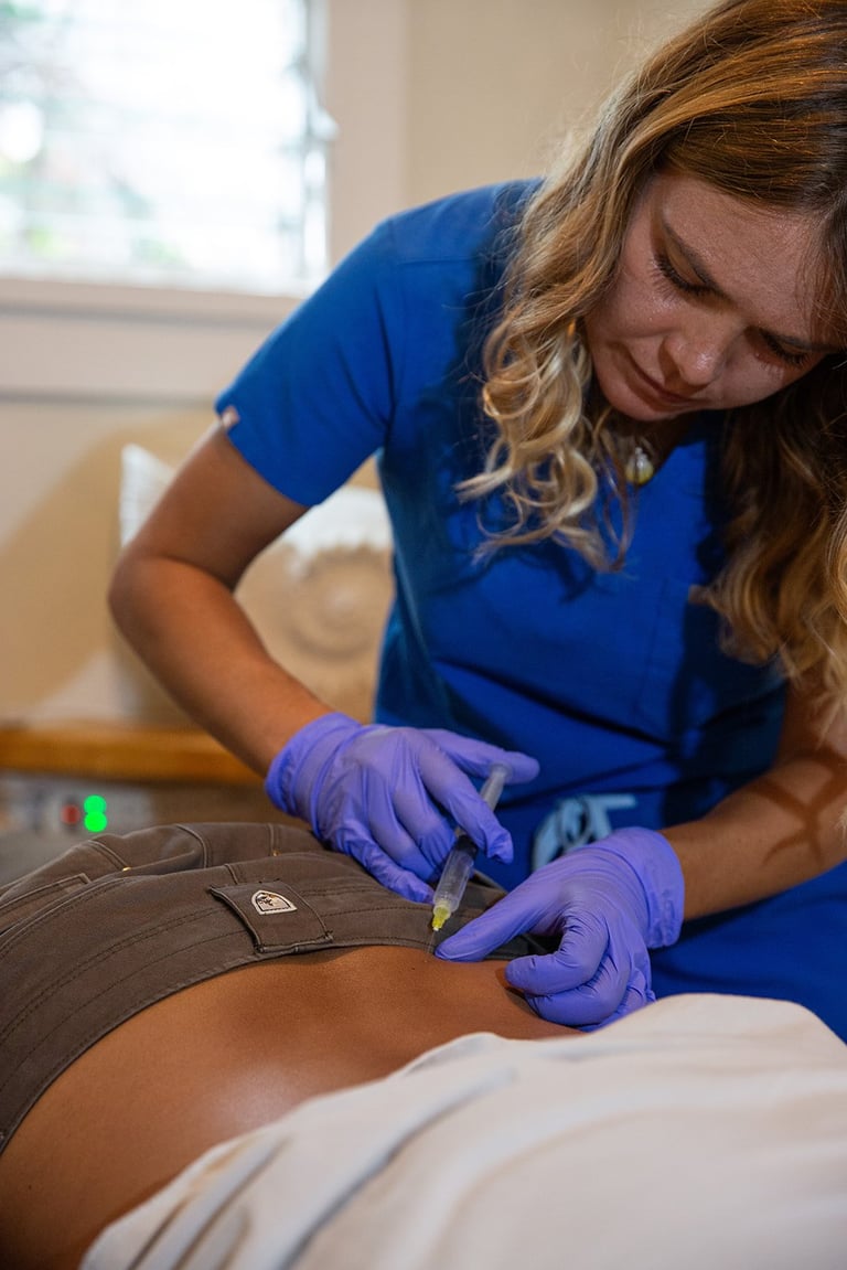 Healthcare provider in blue scrubs wearing purple gloves performing a medical examination on a patient's abdomen